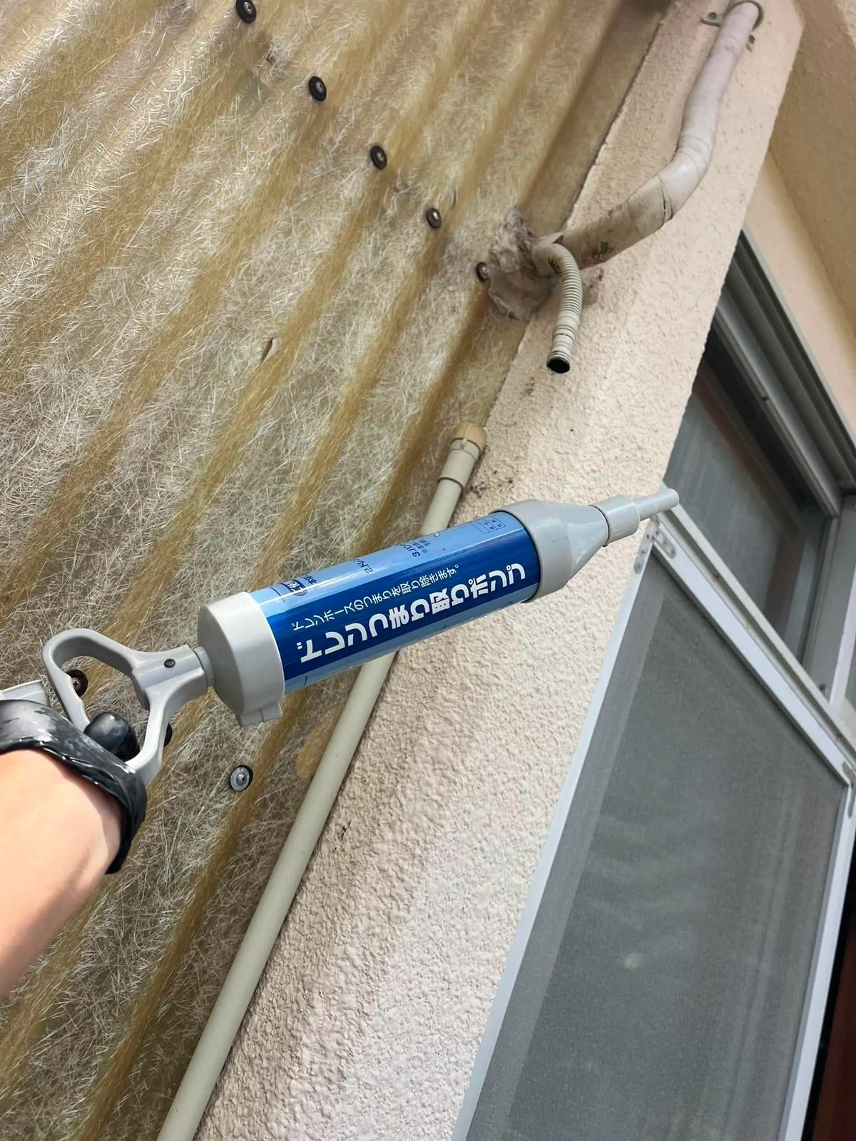 外壁の配管穴まわりにコーキングを打ち直しているところ